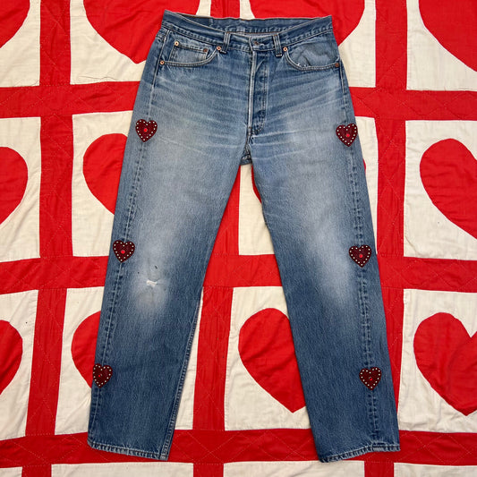 Custom vintage Levi’s with cut out red leather hearts on each side of the legs.
