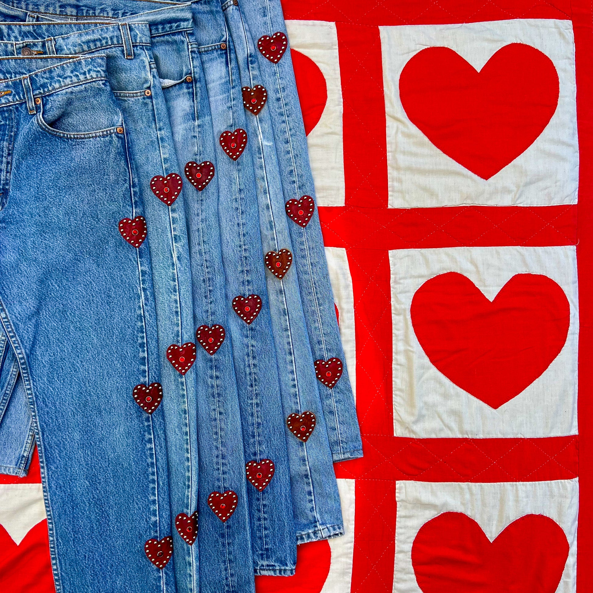Custom vintage Levi’s with red leather hearts on the side of the jeans. Photo showcases what it looks like