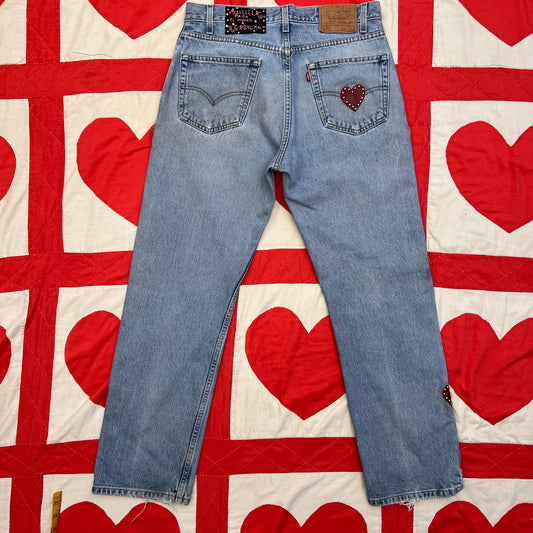 Custom vintage Levi’s with cut out red leather hearts on each side of the legs.

Back right pocket has a red leather tag