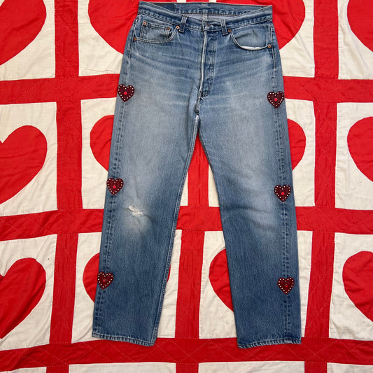 Custom vintage Levi’s with cut out red leather hearts on each side of the legs.