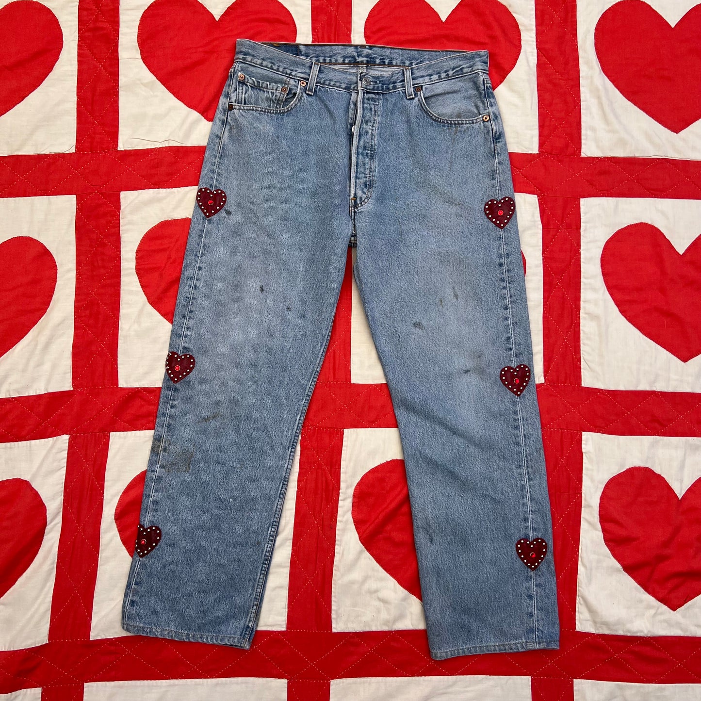 Custom vintage Levi’s with cut out red leather hearts on each side of the legs.