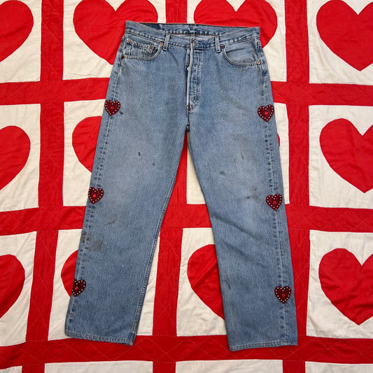 Custom vintage Levi’s with cut out red leather hearts on each side of the legs.