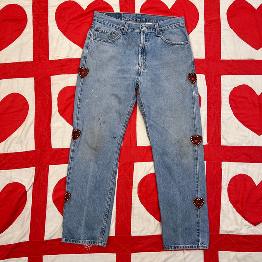 Custom vintage Levi’s with cut out red leather hearts on each side of the legs.