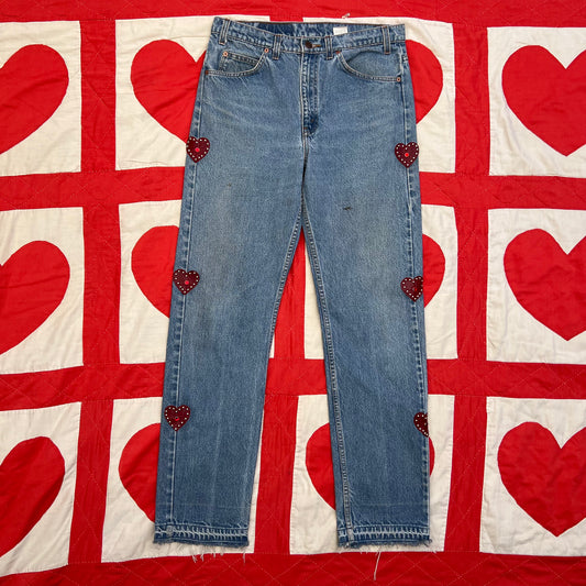 Custom vintage Levi’s with cut out red leather hearts on each side of the legs.