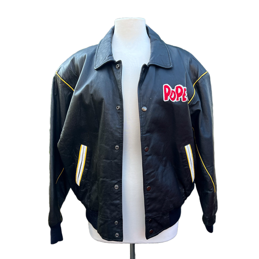 Black leather jacket with Popeye the sailor and his friends on the back of the jacket.

Red wording of 'Popeye'